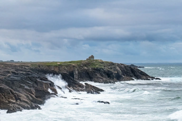 a large body of water next to a rocky shore